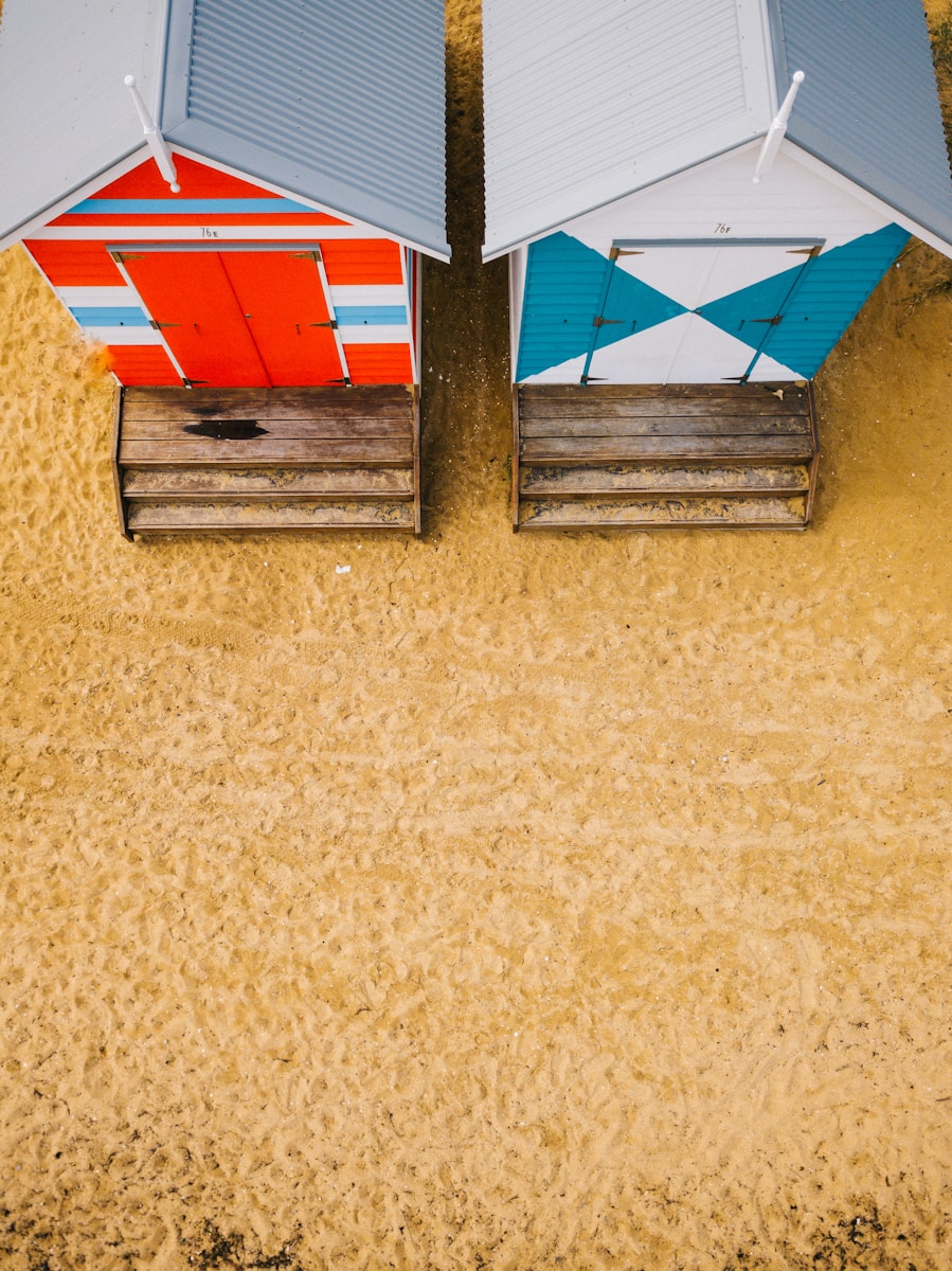aerial photo of two blue and red wooden sheds on desert photo